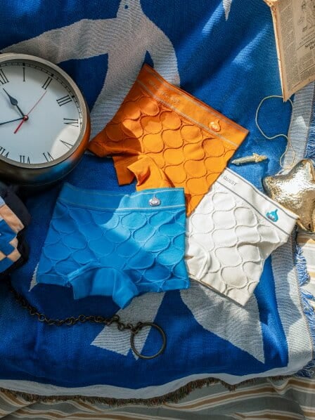 ブルーの布の上に置かれたボクサーショーツの平置きカット